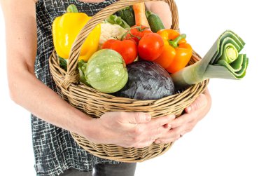 Bir sepet sebze dolu tutan kadın