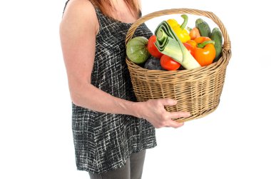 Bir sepet sebze dolu tutan kadın