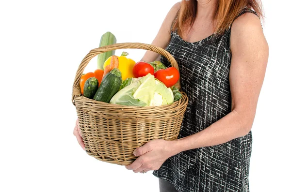 Bir sepet sebze dolu tutan kadın
