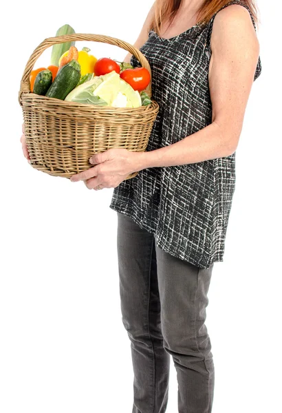 Woman holding a basket full of vegetables — Stock Photo, Image