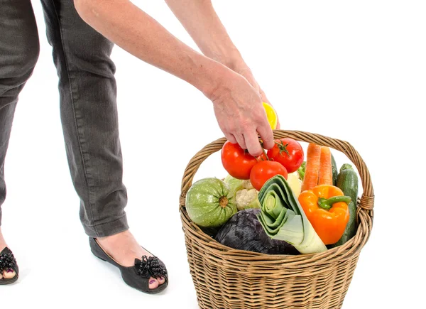 Woman with a basket full of vegetables — Stock Photo, Image