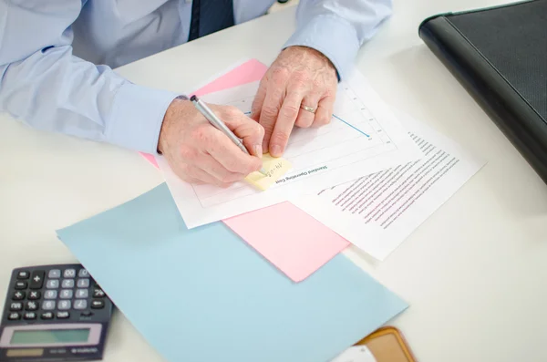 Empresario tomando una nota en un post que — Foto de Stock