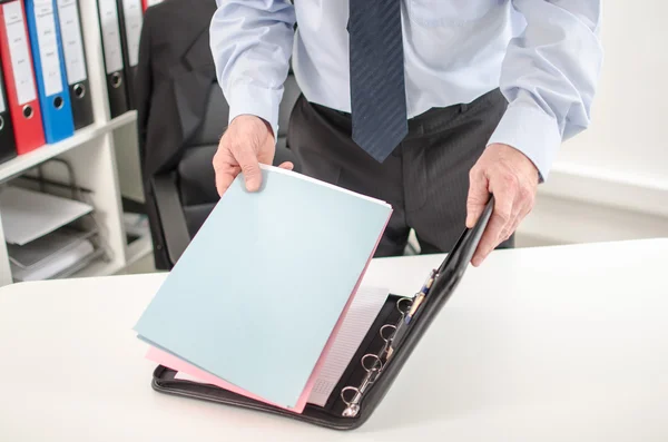 Empresario tomando carpeta de su maletín — Foto de Stock