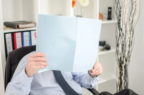 Relaxed businessman analyzing a document — Stock Photo, Image