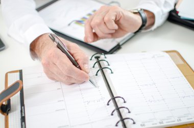 İş adamı saatine bakıyor.