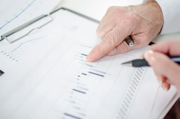 Teamwork on a stock market chart — Stock Photo, Image