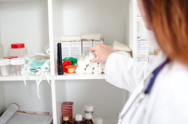 Kadın doktor bir bandaj bir raf alarak