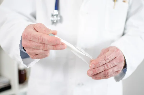 Doctor holding a medical thermometer — Stock Photo, Image