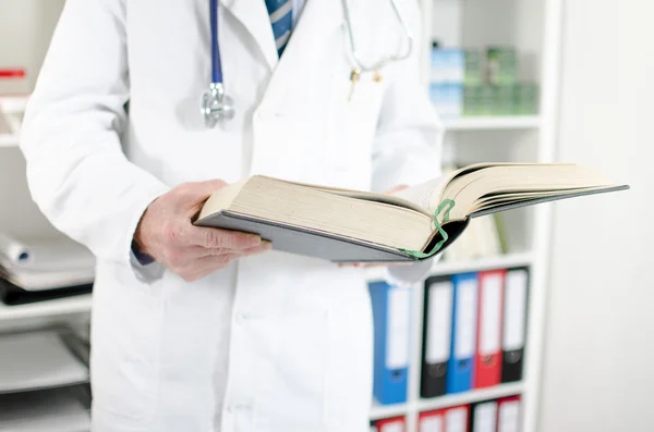 Doutor lendo um livro médico — Fotografia de Stock