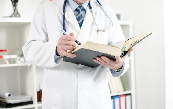 Doctor reading a medical book — Stock Photo, Image