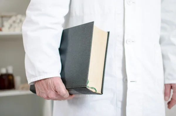 Läkaren håller en medicinsk bok under armen — Stockfoto