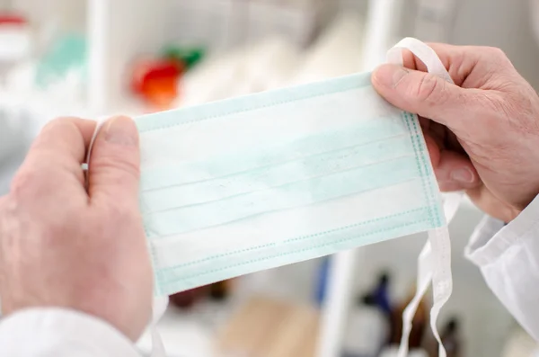 Doctor holding a surgical mask — Stock Photo, Image