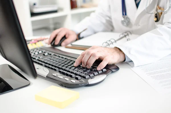 Doctor escribiendo en un teclado de computadora — Foto de Stock