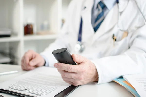 Médico segurando um telefone — Fotografia de Stock