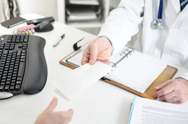 Doctor giving a prescription to his patient — Stock Photo, Image