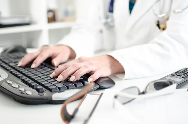 Doctora grabando en un teclado de computadora — Foto de Stock