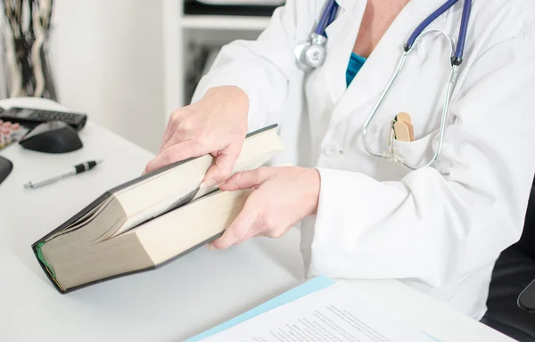 Doctora abriendo un libro médico —  Fotos de Stock