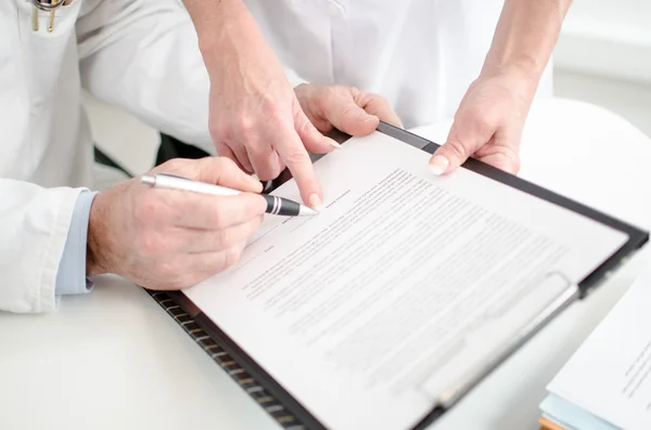 Doctors signing a medical report — Stock Photo, Image