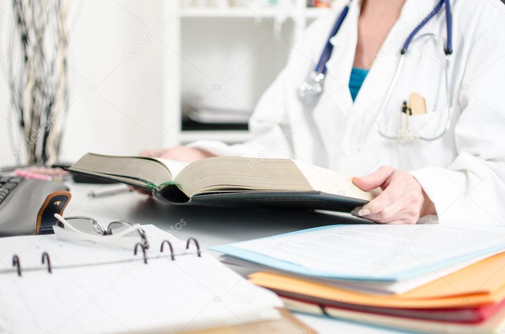 Female doctor reading a medical book