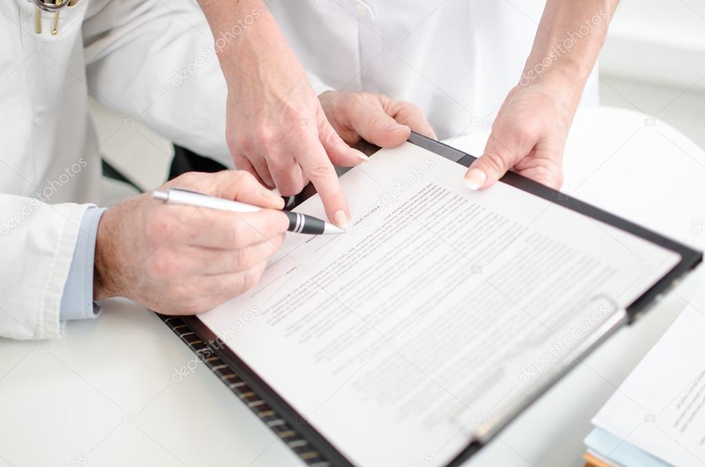 Doctors signing a medical report