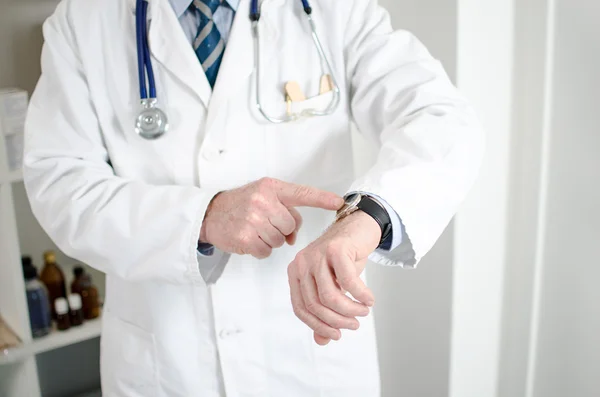 Arzt zeigt seine Uhr mit dem Finger — Stockfoto