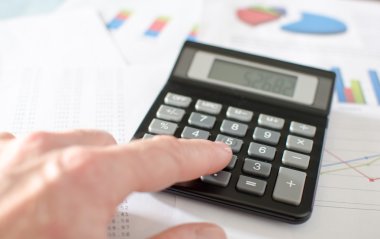 İş kadını hesap makinesiyle çalışıyor