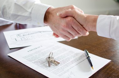 Estate agent shaking hands with his customer clipart