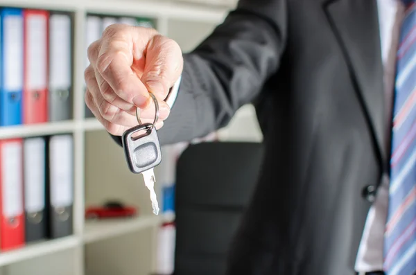 Salesman holding car key — Stock Photo, Image