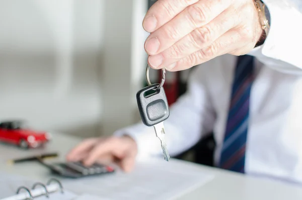 Car salesman holding a key — Stock Photo, Image