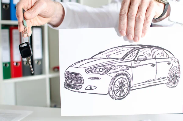 Salesman holding a key and showing a car design — Stock Photo, Image