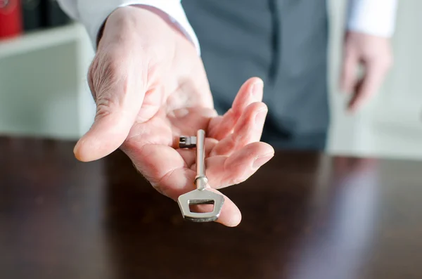 Empresário segurando uma chave — Fotografia de Stock