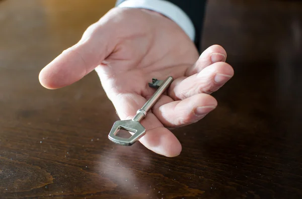 Empresário segurando uma chave — Fotografia de Stock