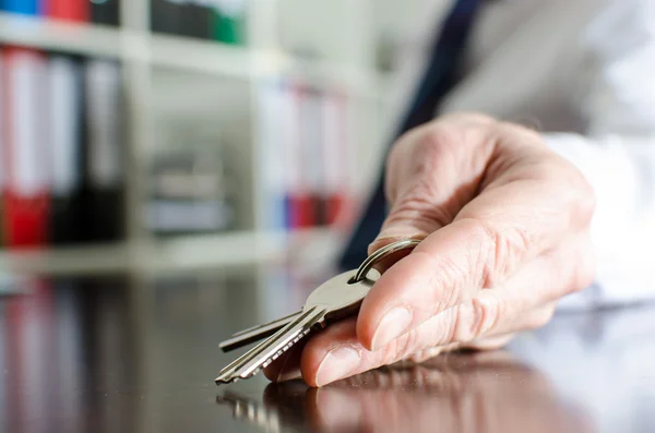 Estate agent showing house keys — Stock Photo, Image
