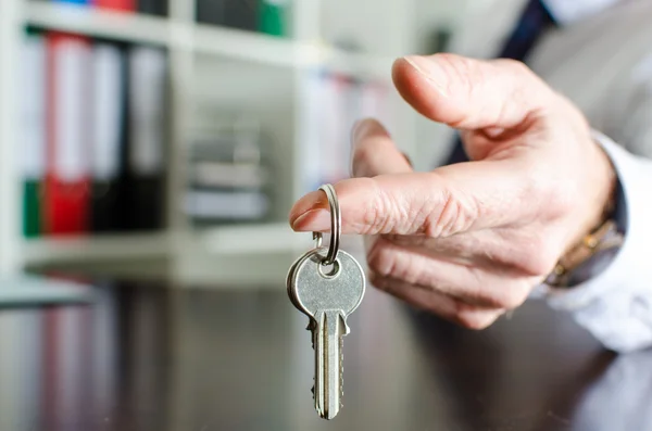 Immobilienmakler zeigt Hausschlüssel — Stockfoto