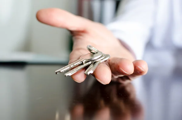 Агент по недвижимости показывает ключи от дома — стоковое фото