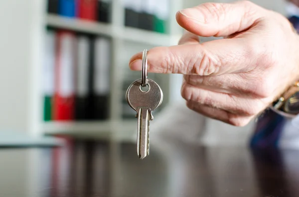 Агент по недвижимости показывает ключи от дома — стоковое фото