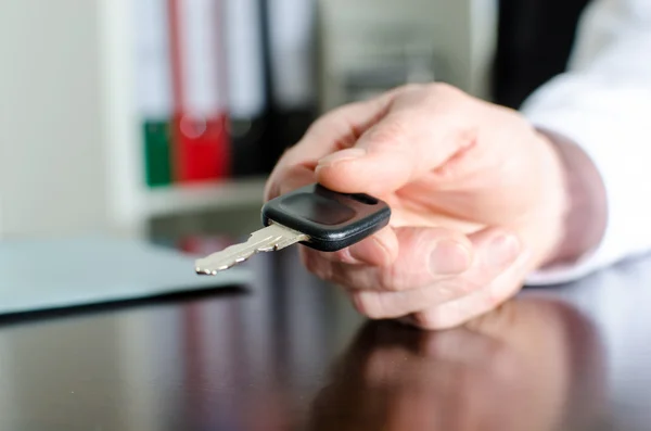 Salesman holding car key — Stock Photo, Image