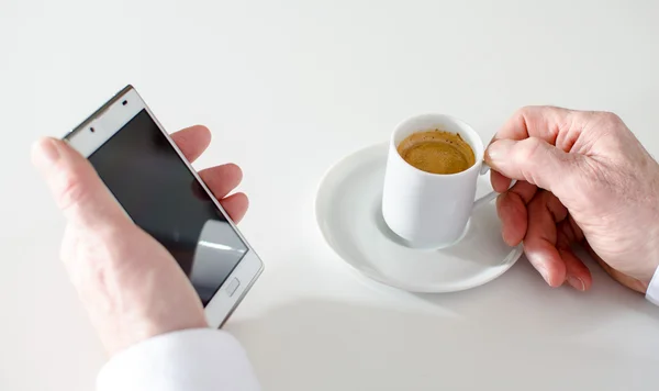 Bir telefon ve bir kahve tutan adam — Stok fotoğraf