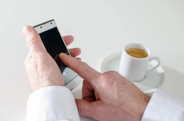 Man texting met smartphone en drinken een kopje koffie — Stockfoto