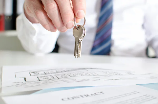 Estate agent holding house keys — Stock Photo, Image