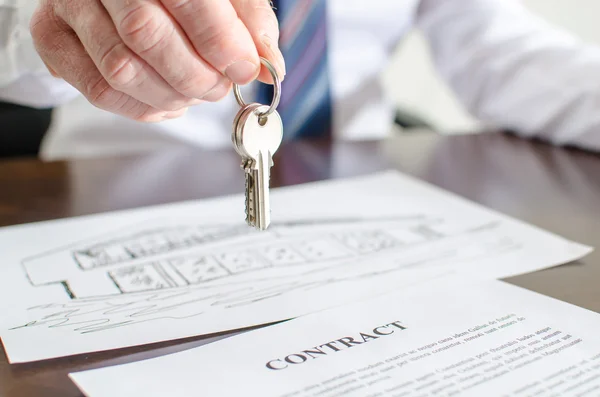 Estate agent holding house keys — Stock Photo, Image