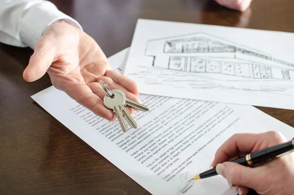 Женщина подписывает контракт на недвижимость — стоковое фото