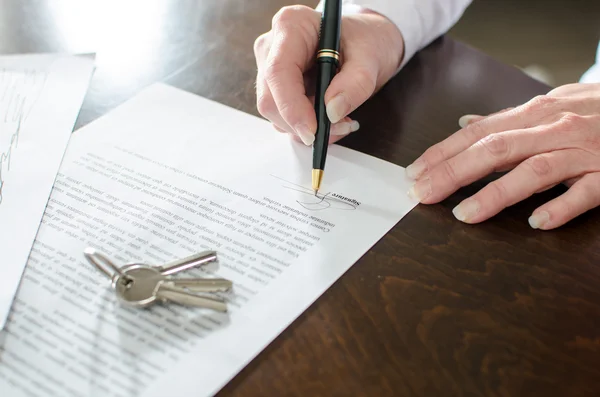 Vrouw ondertekening van een contract van onroerend goed — Stockfoto