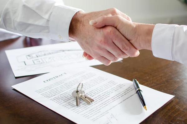 Agente imobiliário apertando as mãos com seu cliente — Fotografia de Stock
