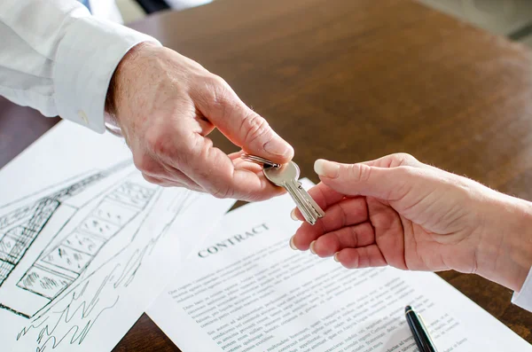 Agente imobiliário dando chaves de casa para o cliente — Fotografia de Stock