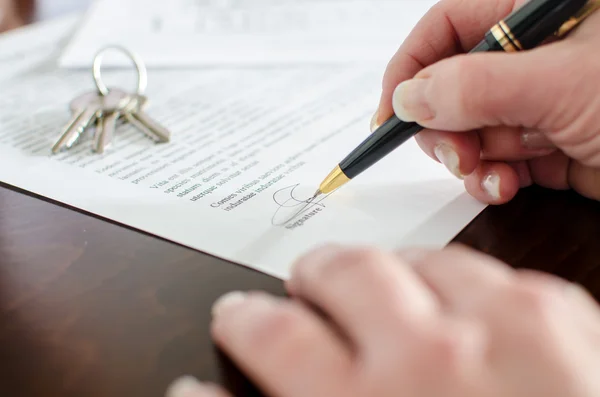 Kvinnan underteckna ett fastigheter kontrakt Stockfoto