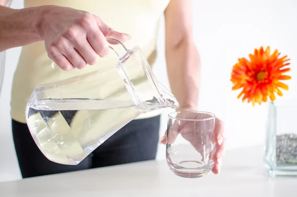 Mujer vertiendo agua en un vaso —  Fotos de Stock