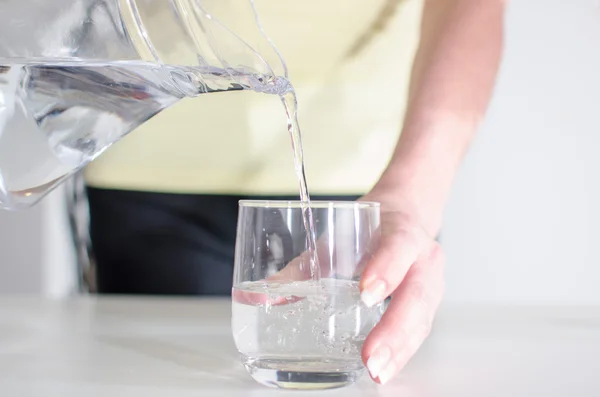 Mujer vertiendo agua en un vaso —  Fotos de Stock