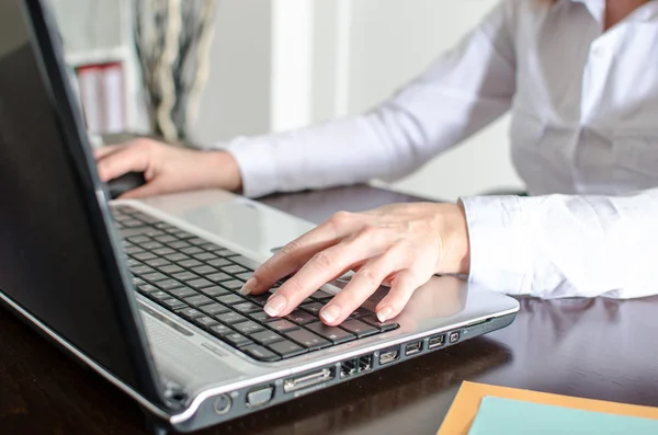 Businesswoman typing on a laptop — Stock Photo, Image