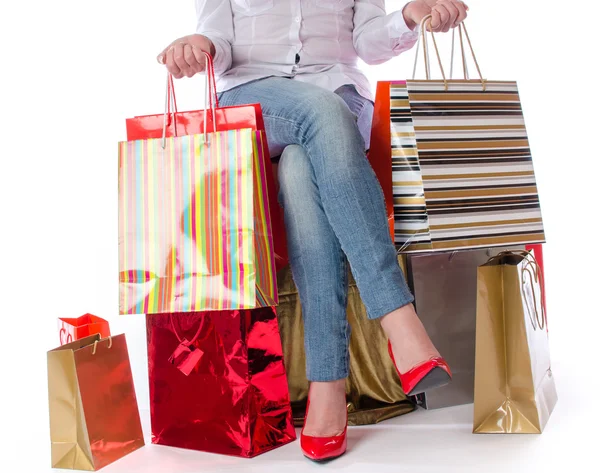 Mulher sentada no meio de sacos de compras — Fotografia de Stock